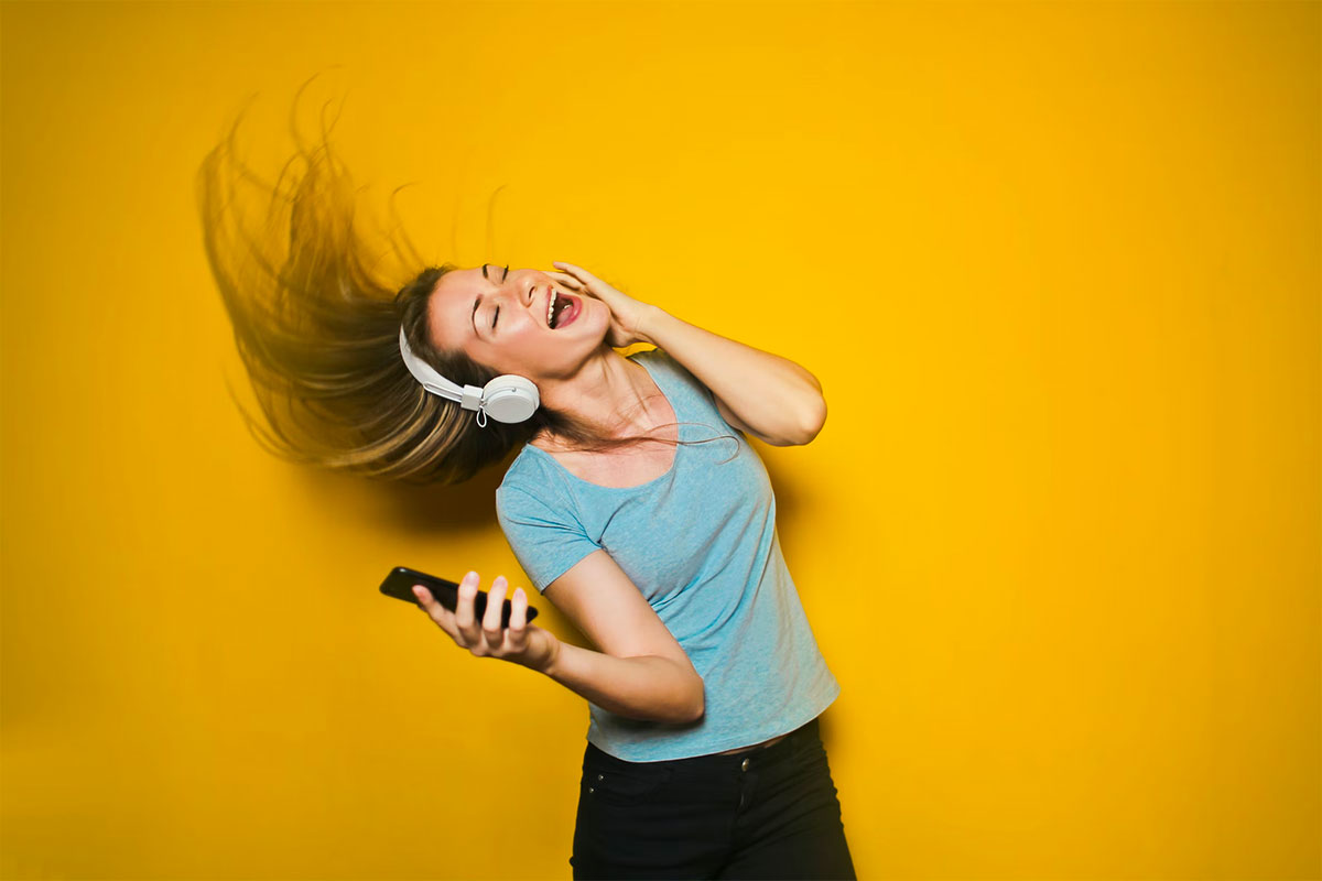 Smiling woman listening to music with headphone